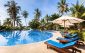 Beautiful tropical beach front hotel resort with swimming pool, sun-loungers and palm trees during a warm sunny day, paradise destination for vacations